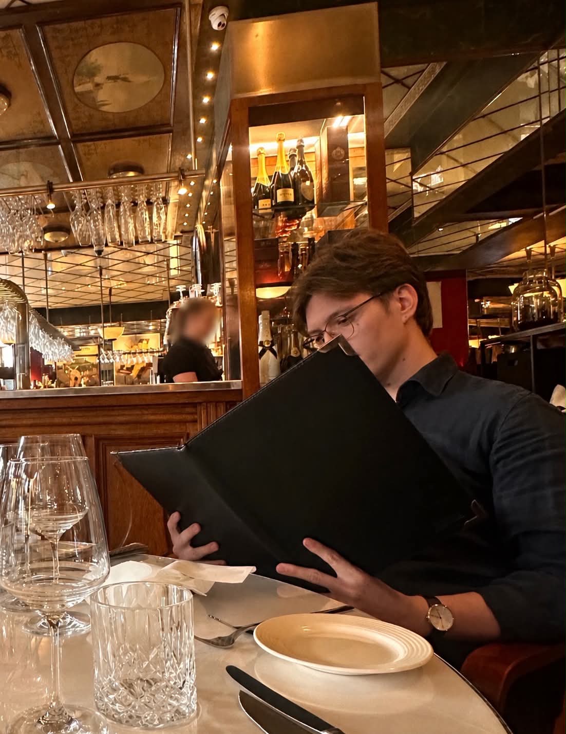 Thomas at a restaurant reading a menu